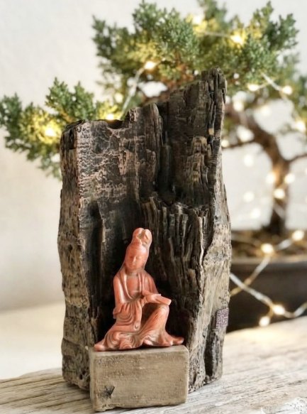 Figura sobre tronco antiguo: Pequeña figura sentada en un nicho de madera envejecida, pieza de colección.