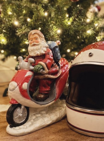 Santa en scooter: Figura de Santa Claus en scooter roja sobre base nevada.
